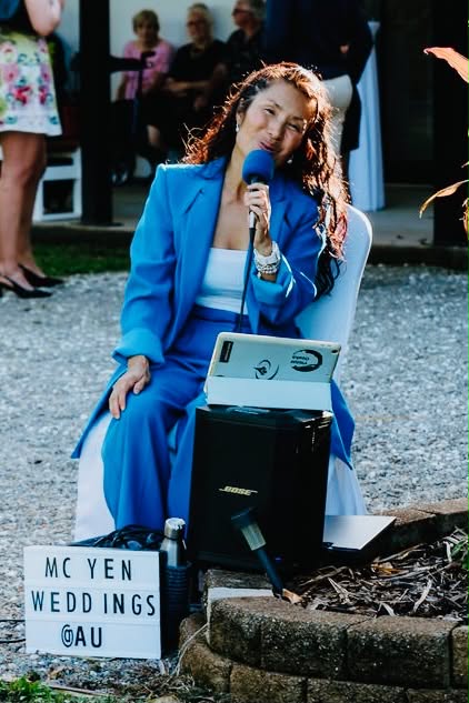 MCyen officiating an outdoor ceremony with the MCyen Weddings sign